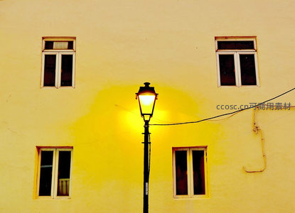暖黄街灯映照米色墙面与窗棂