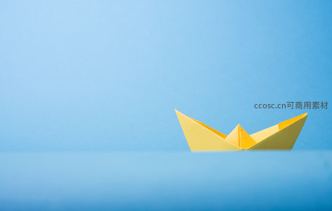 蓝色背景下的黄色纸船静谧漂浮