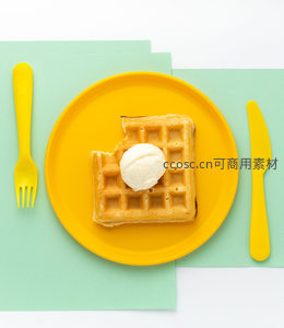 黄盘上的华夫饼配冰淇淋，简约餐具点缀清新绿意