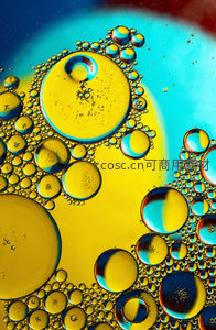 油滴在水中形成彩色泡泡，蓝黄交织如梦幻星云