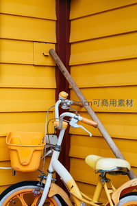 复古黄白单车倚靠明黄墙壁