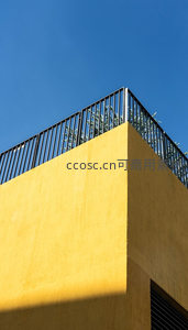 阳光下的黄色建筑角落与蓝天