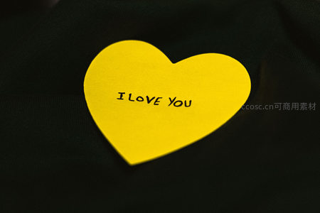 黑色布料上黄色心形便签写着我爱你