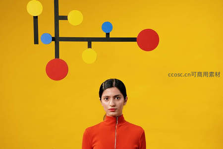 红衣女子立于彩色几何墙前