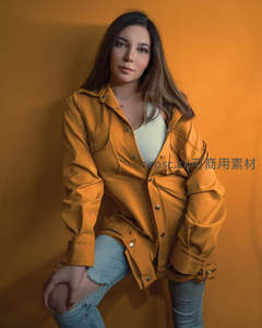 橙色外套美女倚墙时尚肖像