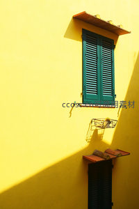 阳光下的柠檬黄墙面与绿窗