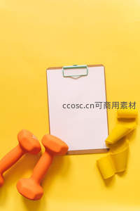 健身器材与空白记事板的黄色桌面布置