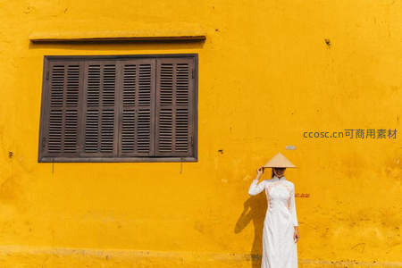 白衣女子戴斗笠立黄墙