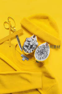 黄色背景上的火龙果与针织帽创意组合