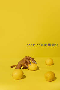 手从孔洞中拿起柠檬的静物画面