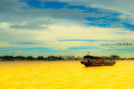 金色河面上游船缓缓行驶于蓝天白云下