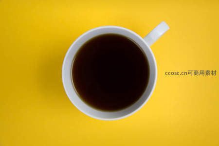 俯拍视角下白色咖啡杯与黄色背景的极简美学