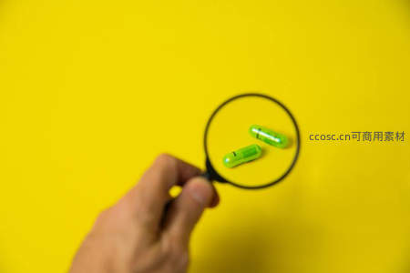 放大镜下的绿色胶囊特写