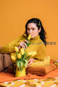 女子手捧黄郁金香嗅闻花香