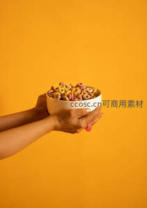 双手捧着一碗色彩缤纷的麦圈