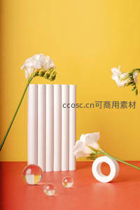 白色花束与几何道具在明黄背景下的静物构图