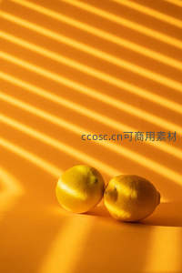 阳光条纹下两颗柠檬的温暖光影静物