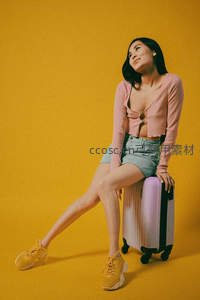 少女倚行李箱憧憬远方