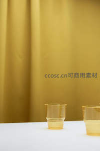 白色台面上的透明黄色塑料杯