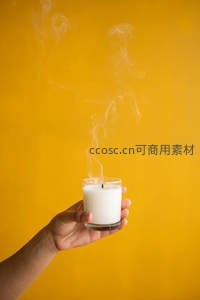 手握香薰蜡烛，袅袅青烟升腾于暖黄背景