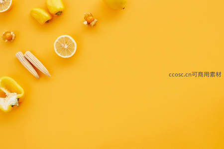 明亮黄色背景上散落新鲜蔬果构图