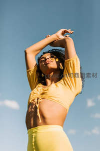 阳光下女子伸展双臂享受自然