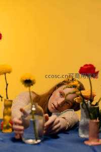 少女在花丛中凝视透明花瓶