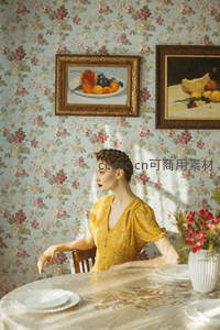 复古花墙前穿黄裙的优雅女子