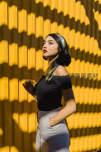 光影交错墙前的时尚女郎