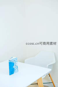 蓝白纹理书本静置于简约白色桌椅旁