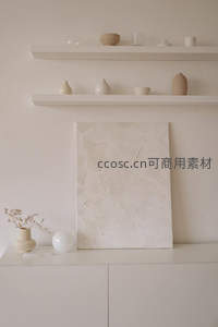 奶油色系装饰画与陶器陈列于简约置物架