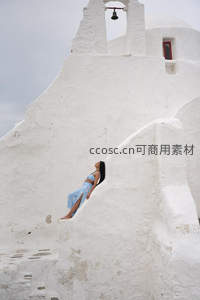圣托里尼蓝裙女子倚白墙