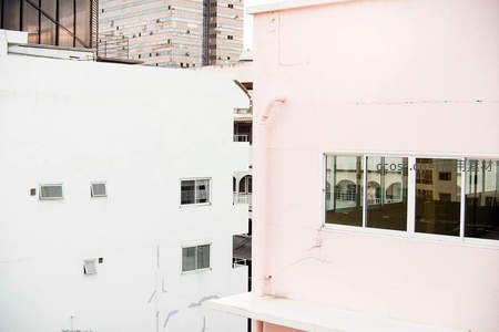 粉白建筑立面交错，城市肌理中的温柔色彩