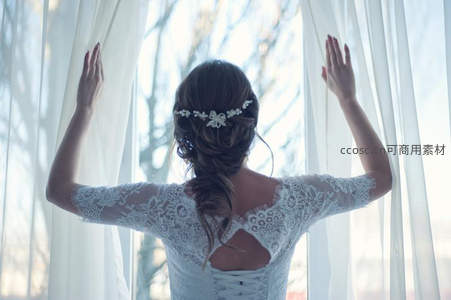 新娘背影轻抚窗帘沐浴晨光
