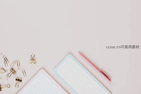 粉色文具与金属夹子的极简桌面