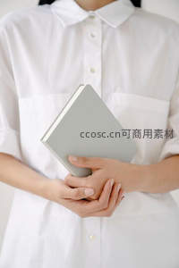 白衣女子手捧灰色笔记本，简约知性