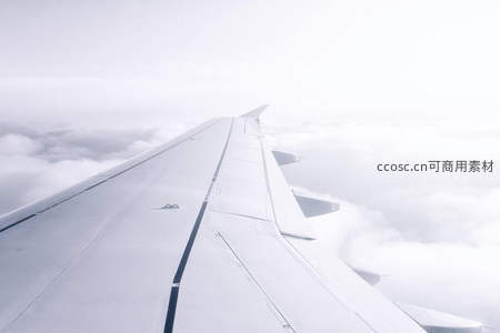 飞机翼尖掠过云海，高空飞行视角
