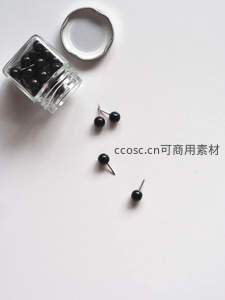 玻璃瓶倾倒黑色图钉，简约静物