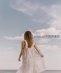 白衣女子背影迎风，海边漫步