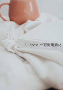 粉色马克杯旁的白色书籍