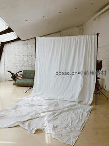 简约摄影棚内白色背景布与绿沙发