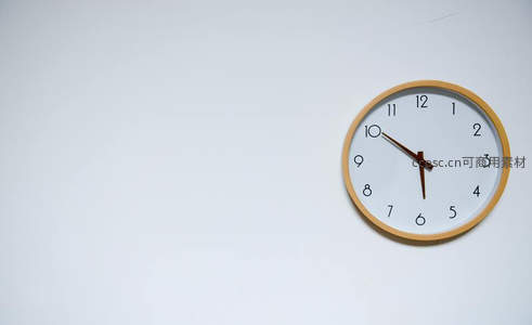 简约木框挂钟静置白墙角落