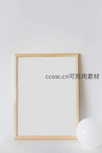 木质画框静立白墙，光影相伴显格调