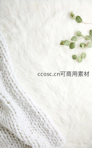 白色毛绒毯与针织围巾的温馨角落