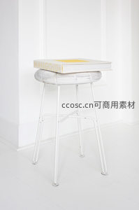 白色藤编凳上放置艺术书籍