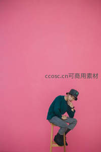 粉墙前沉思的青年男子