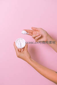 双手涂抹白色面霜的护肤特写