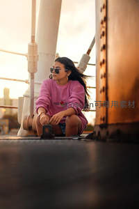 夕阳下桥上的粉色卫衣少女