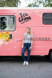 女孩倚靠粉色冰淇淋车微笑