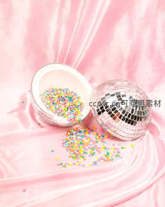 粉色丝绒上的迪斯科球与彩色糖珠